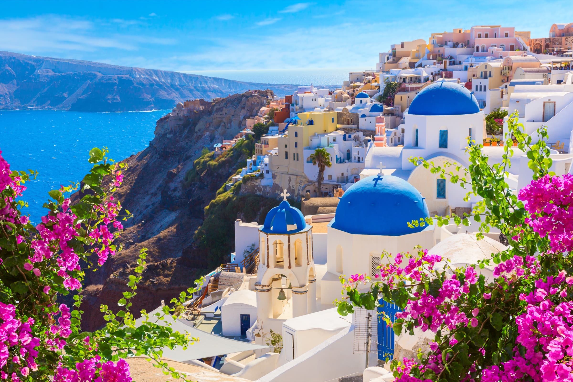 Santorini, Greece — caldera-edge cliffside and white-and-blue Cycladic architecture.