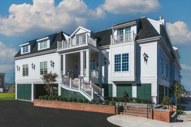 Exterior view of the white shingled hotel with dark rooflines, elevated entryway, and surrounding driveway.