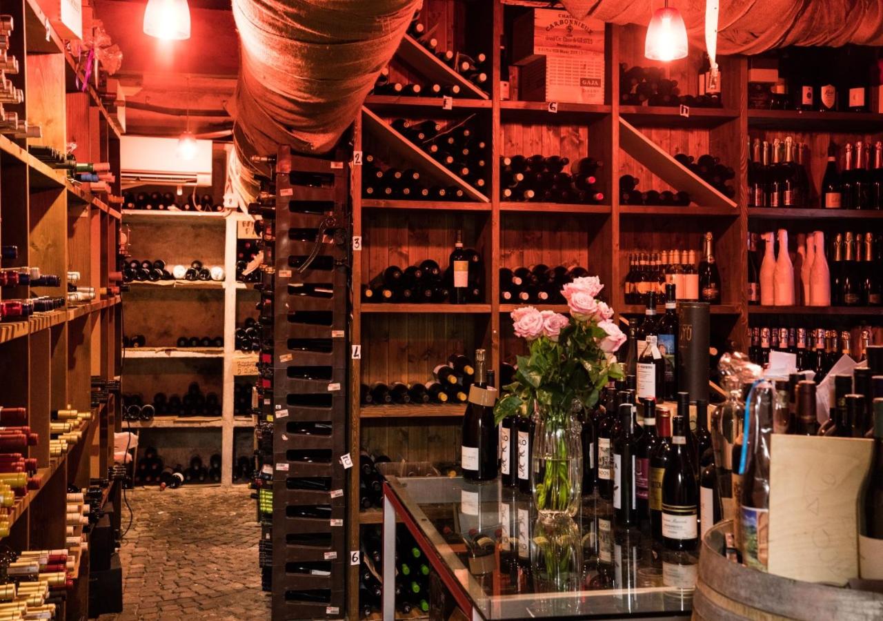 A wine cellar with floor-to-ceiling wooden racks filled with bottles and illuminated by warm lights.