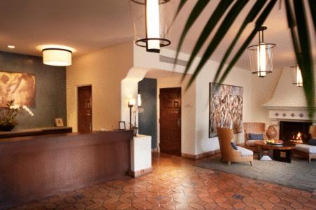 A lobby with terracotta tile flooring, a wooden reception counter, and a fireside seating area.
