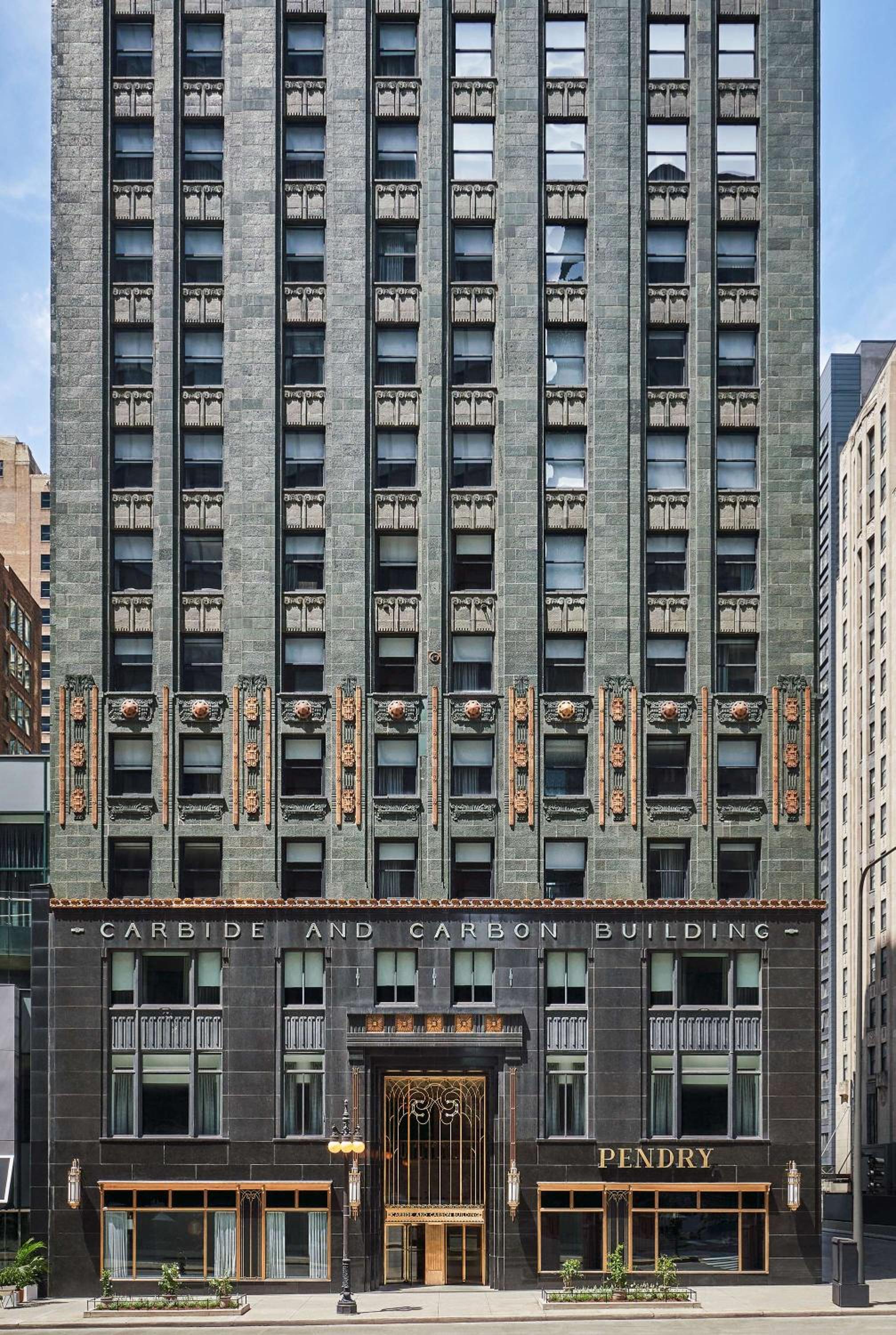 The Carbide and Carbon Building exterior featuring dark stone and gilded detailing around the entrance.