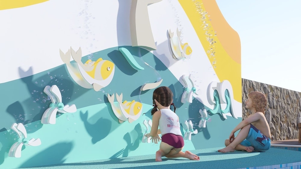 Children playing at a colorful interactive water wall decorated with fish motifs and turning wheels.