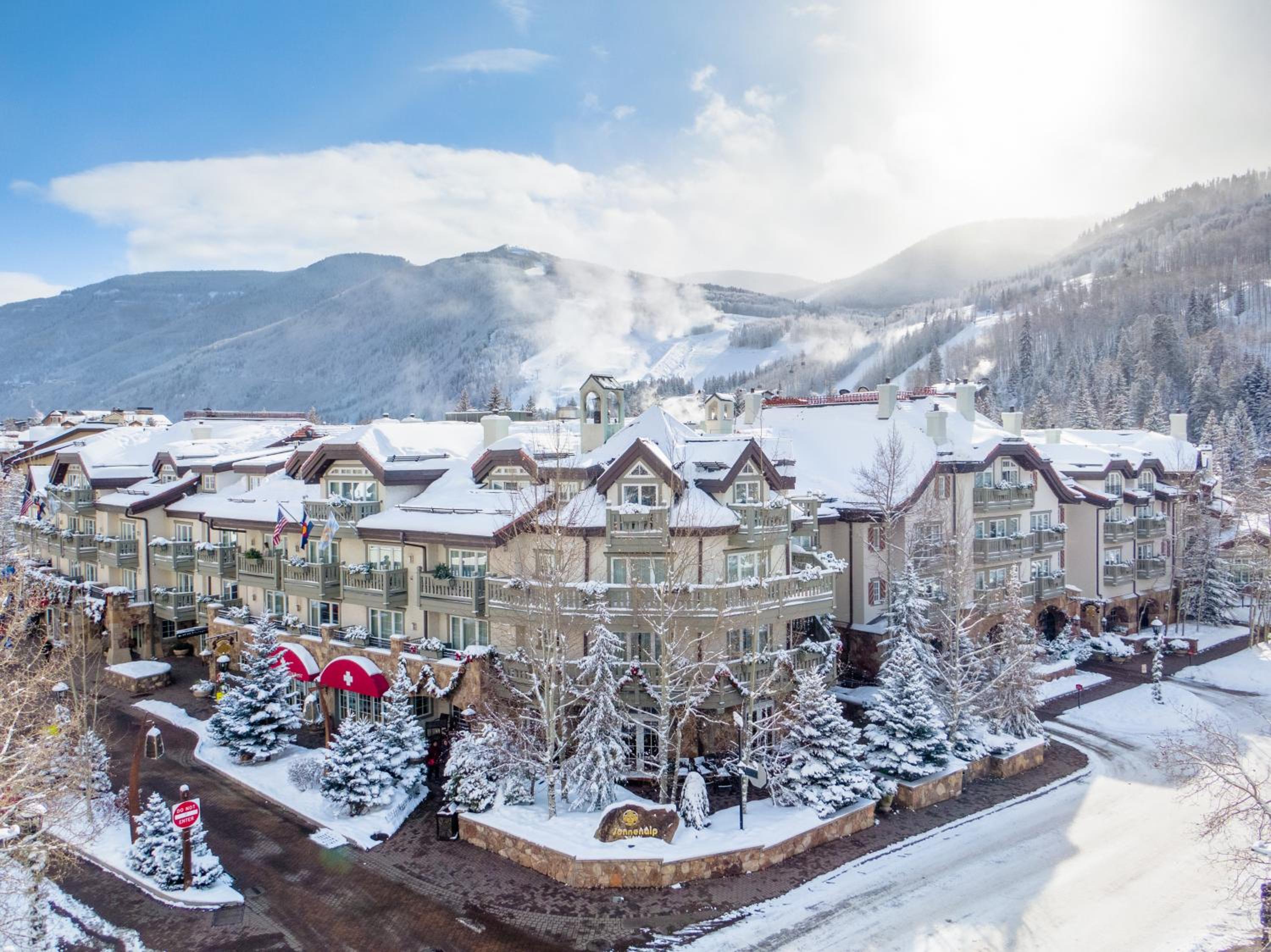 Snowy rooftops and alpine facade of Sonnenalp set against snow-covered mountains.