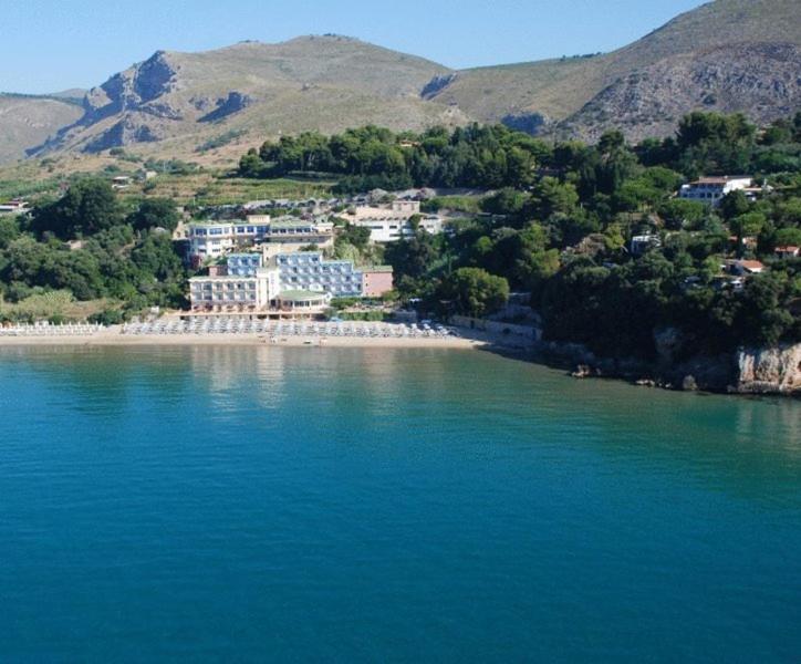 Summit Hotel sits on a sandy cove bordered by wooded hills and calm blue water.