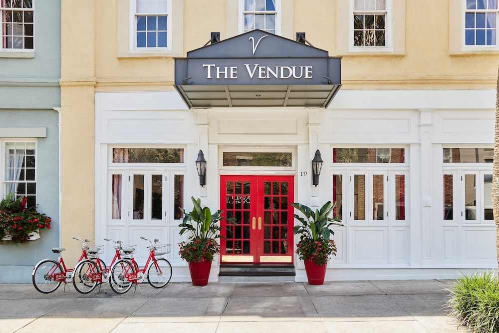 Facade of The Vendue featuring red doors beneath an awning, with bicycles parked on the sidewalk.
