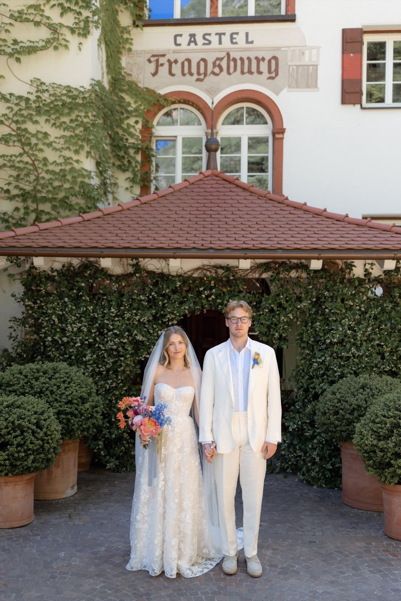 Walt and Perrie standing outside Castel Fragsburg in Merano, Italy, on their wedding day