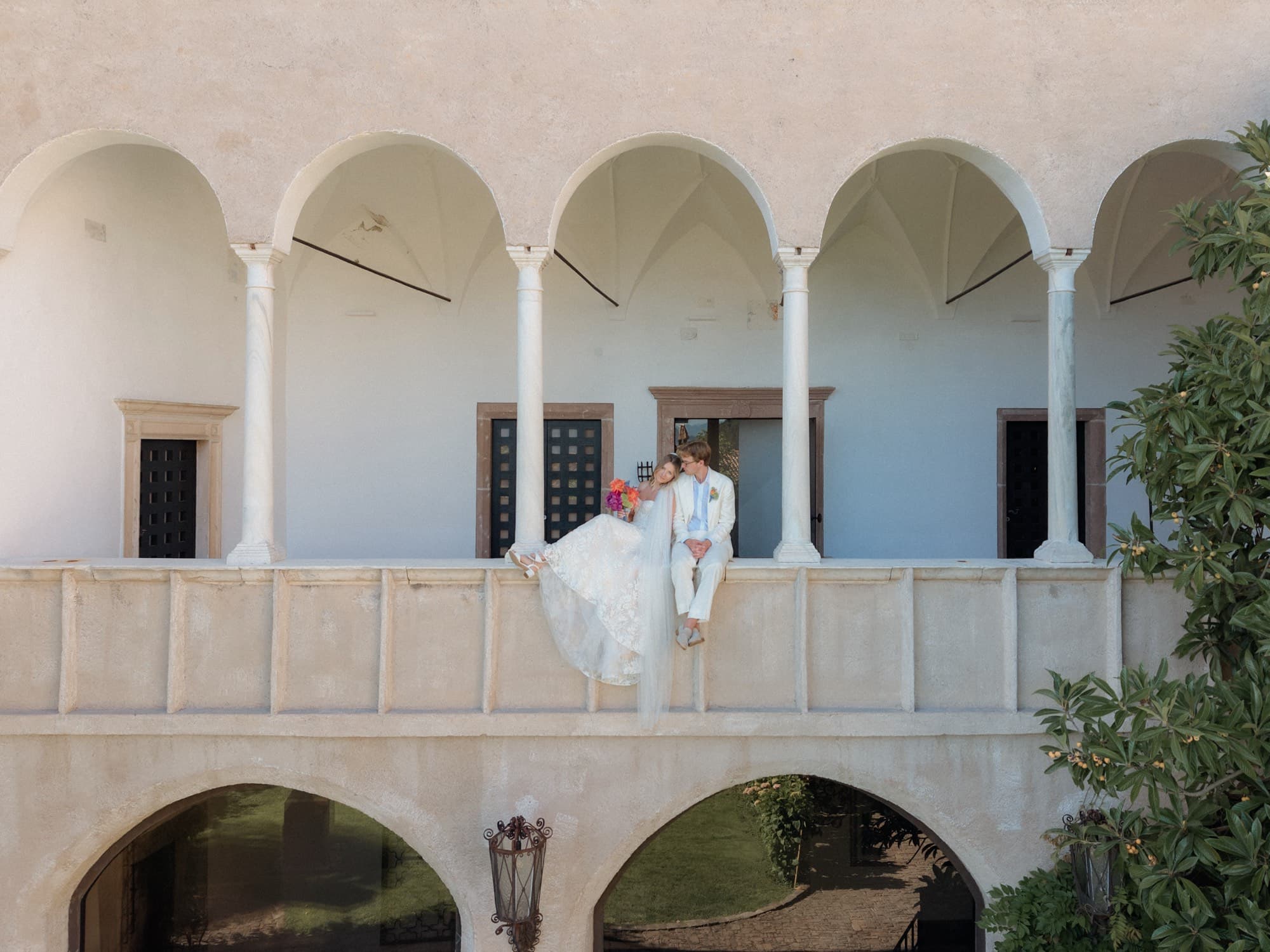 Walt and Perrie seated on the arched stone terrace of their wedding venue in South Tyrol