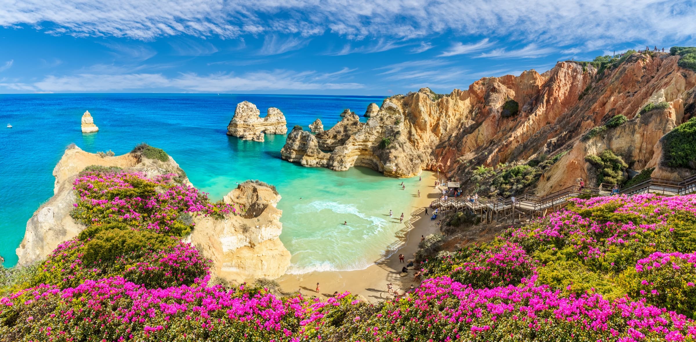 A coastal cliffside view of the Algarve, Portugal, golden cliffs meeting the Atlantic.