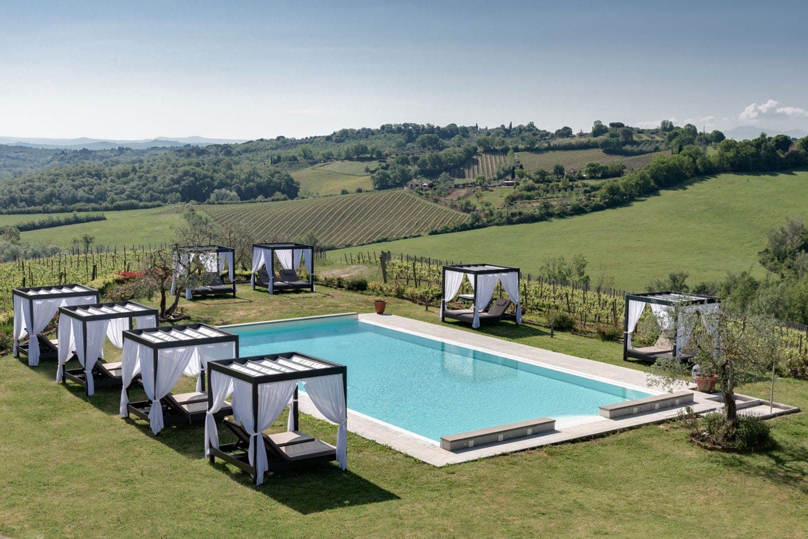 Swimming pool with cabanas and a view of vineyards and hills