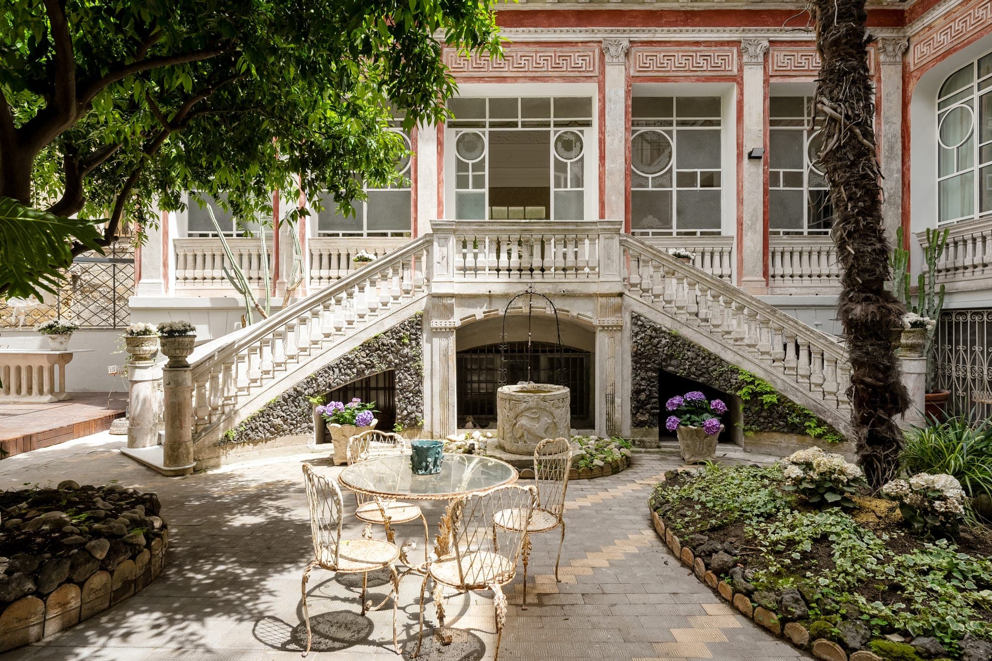 Courtyard with a well, staircase, and outdoor seating area.