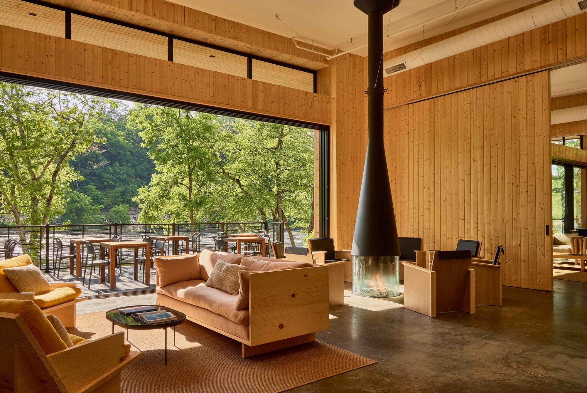 Interior lounge with fireplace and outdoor seating area visible