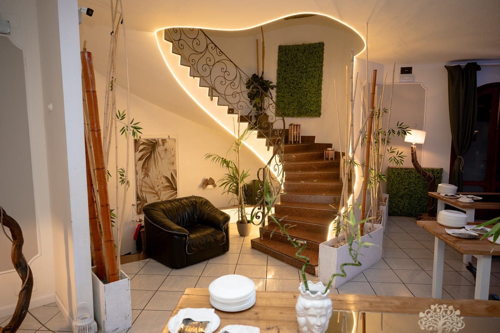 Interior staircase with decorative bamboo and green wall panels.