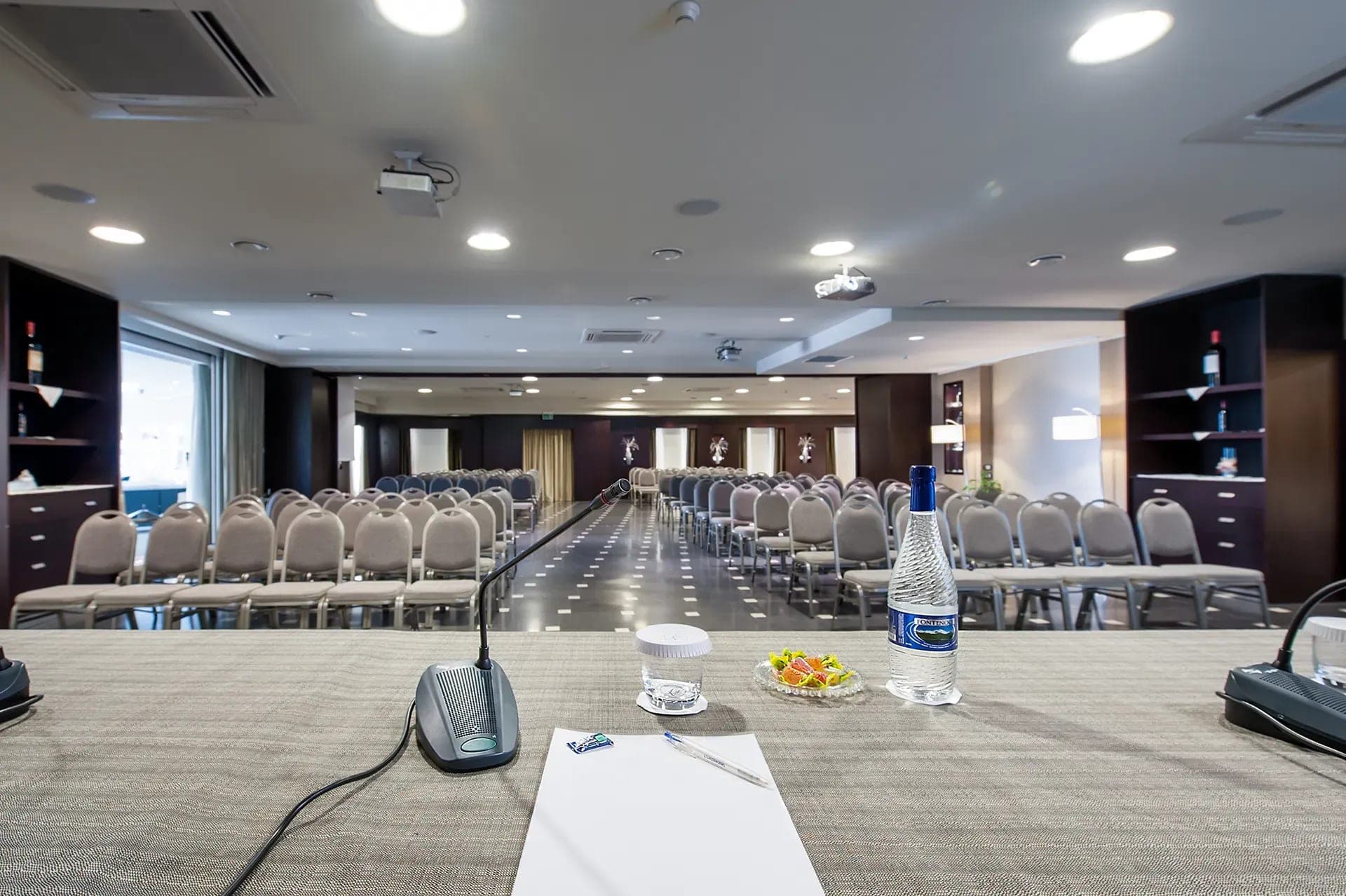A conference room with rows of chairs and a table in the foreground.