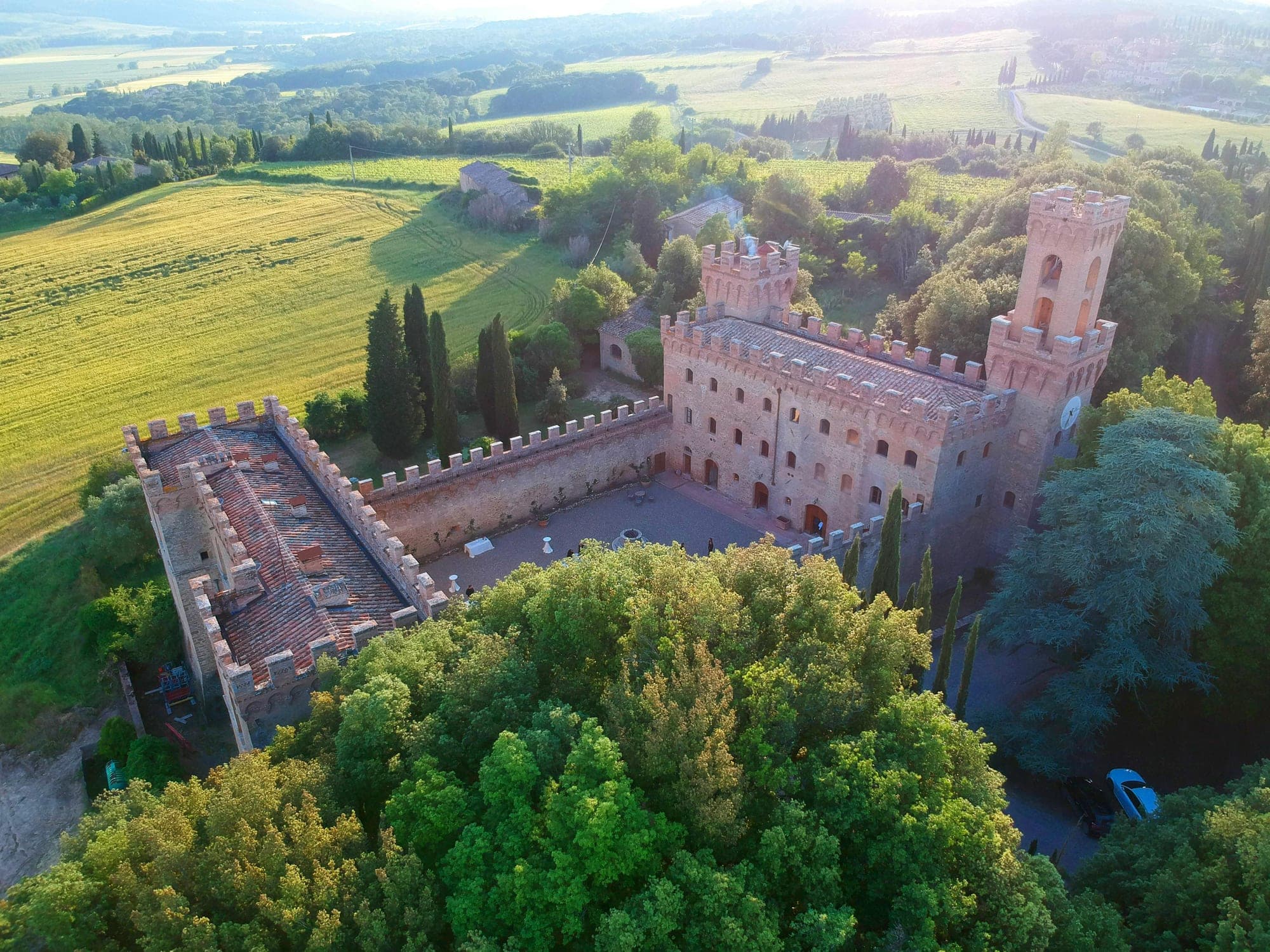 Aerial view of a castle venue surrounded by trees and fields.