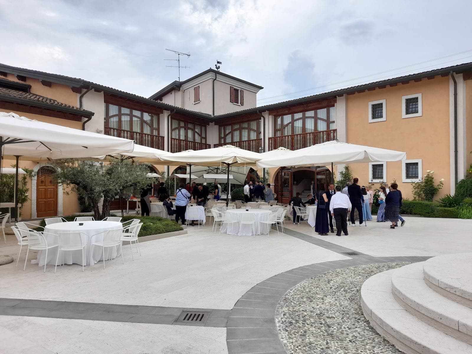 Courtyard with tables and umbrellas outside a building.