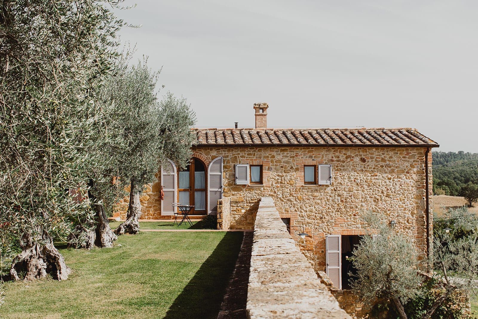Stone building with olive trees and a lawn