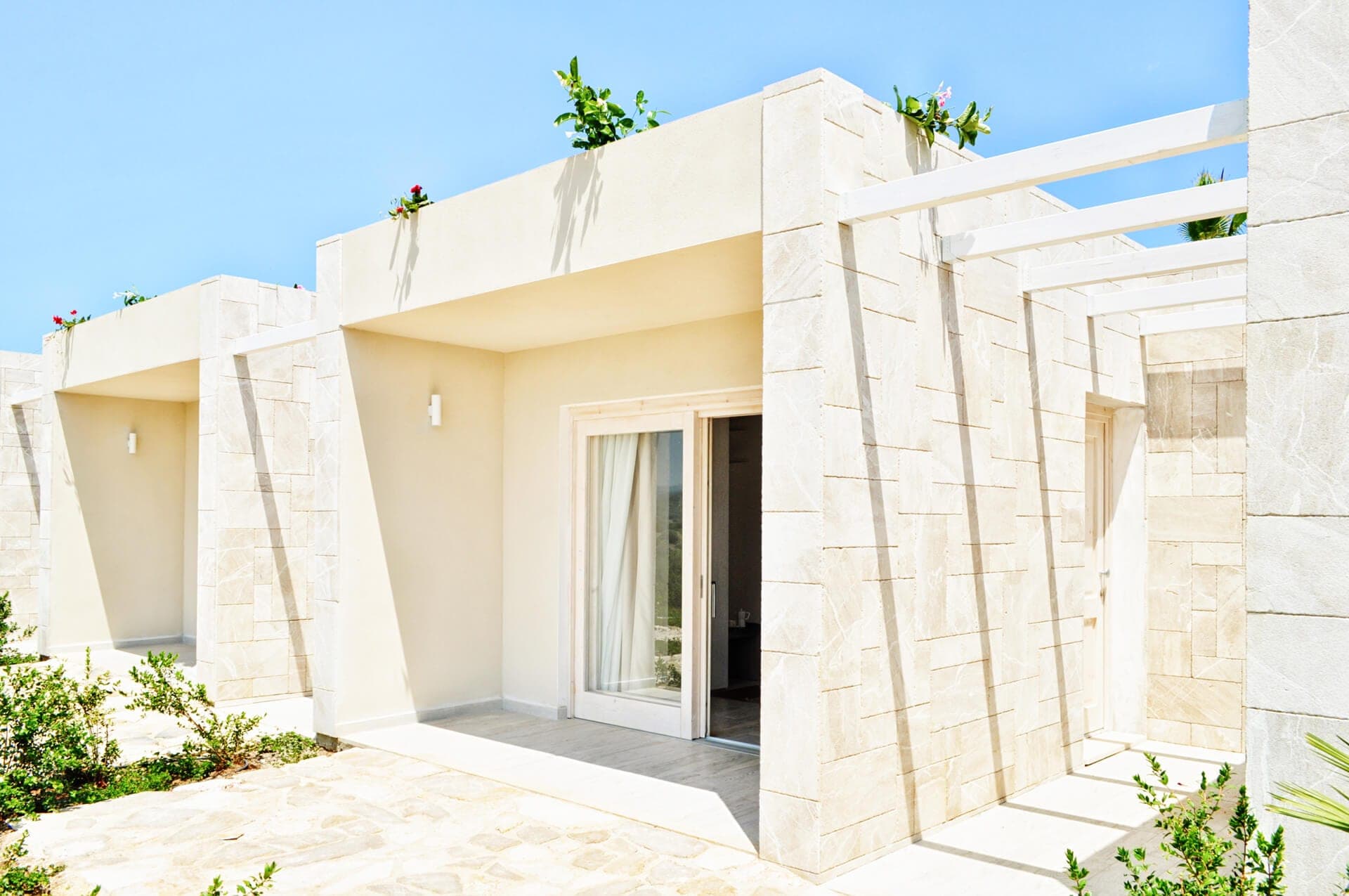 Exterior of a building with stone facade and sliding glass doors.
