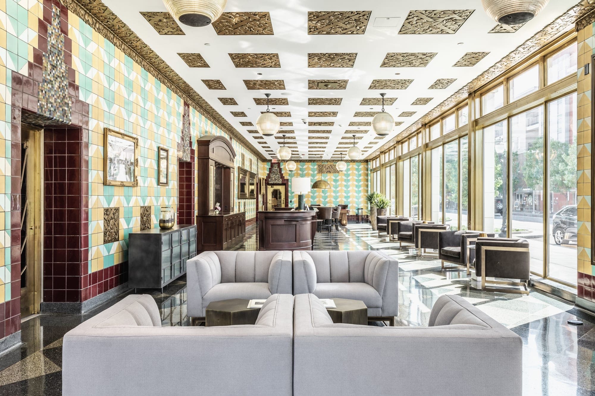 Lobby with colorful tiled walls, seating, and large windows.