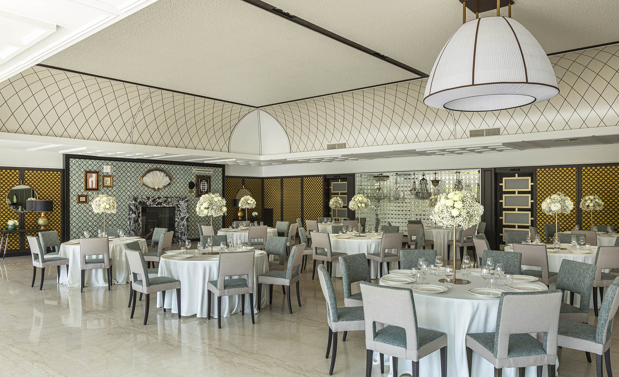 A reception room with round tables set for a wedding