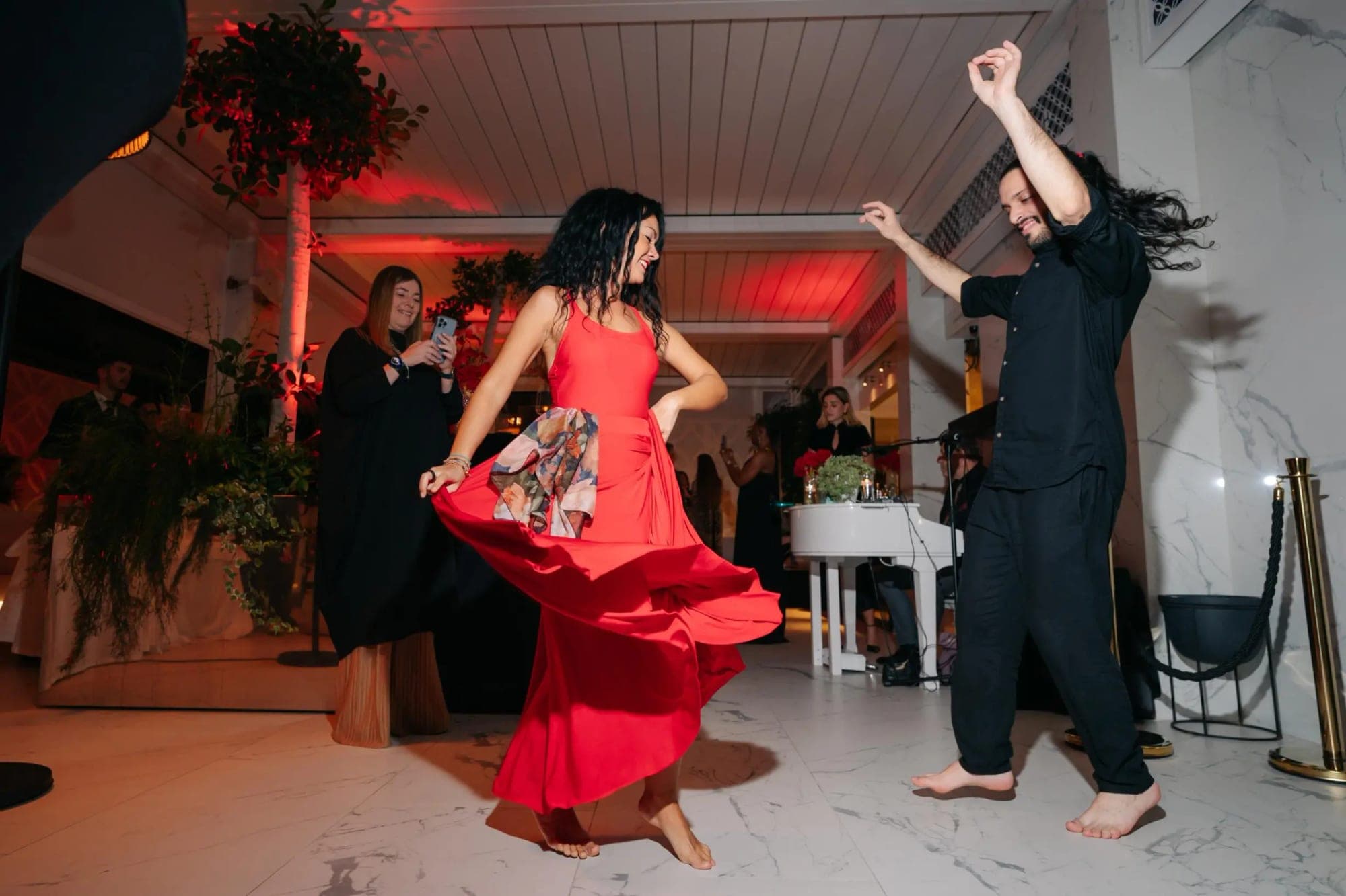 A couple dances at a wedding reception with red lighting.