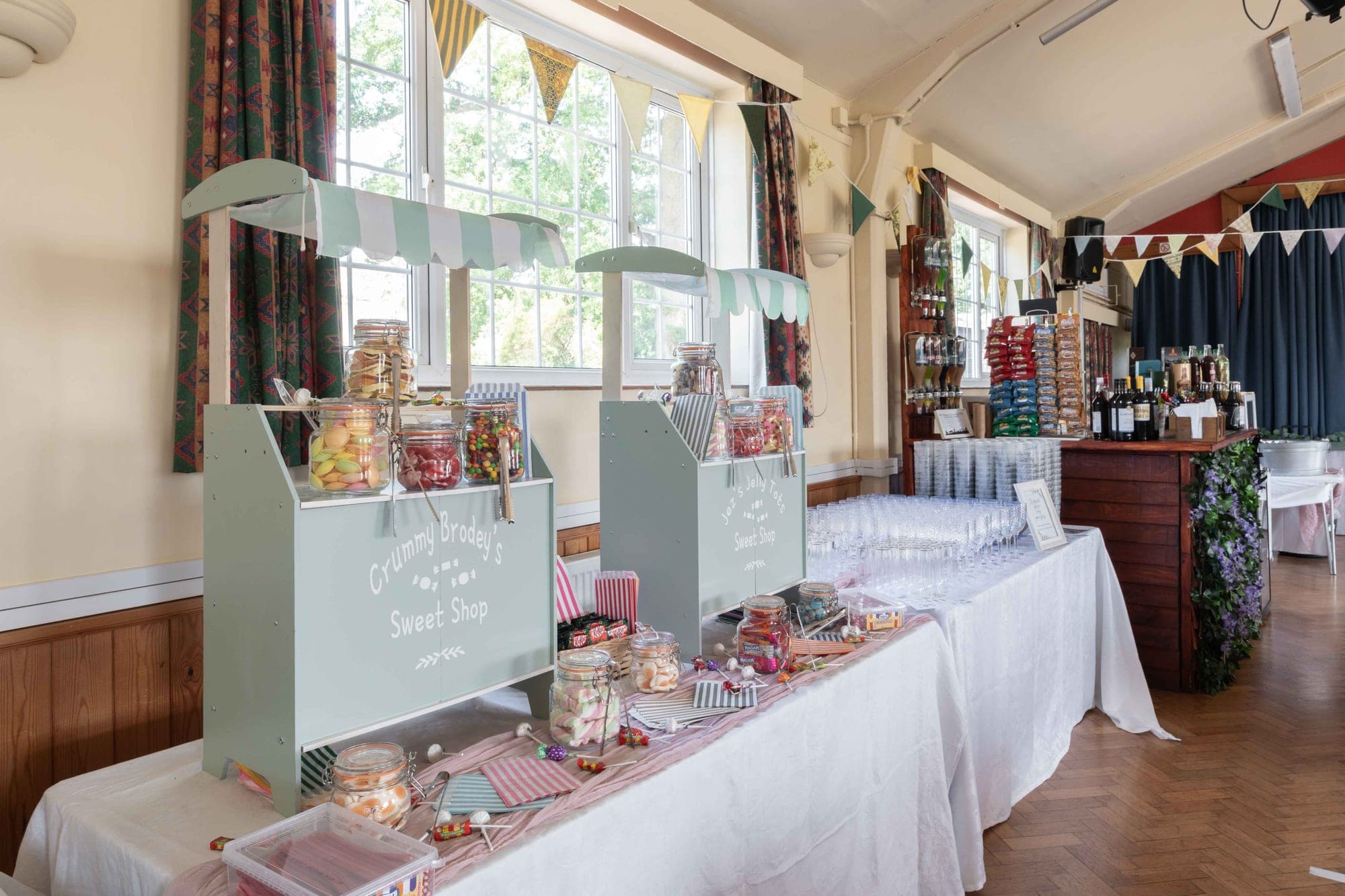 A sweet shop display with jars of candy and drinks in a hall.