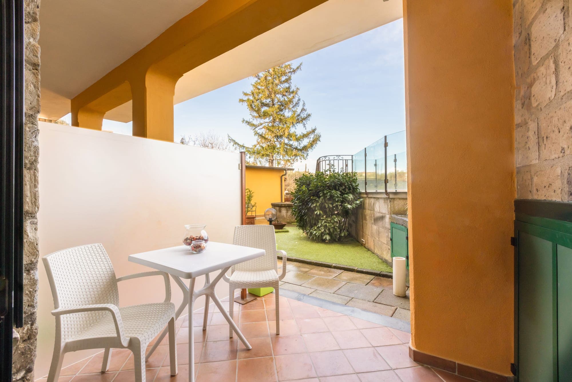 Patio with table and chairs overlooking a garden