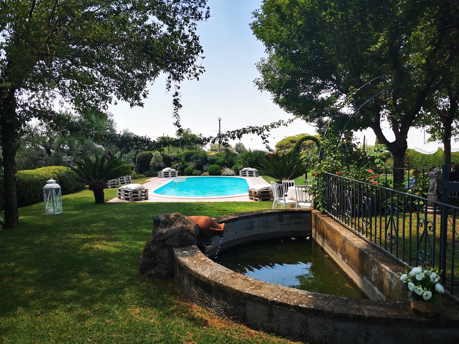 A garden with a swimming pool, seating, and a water feature.