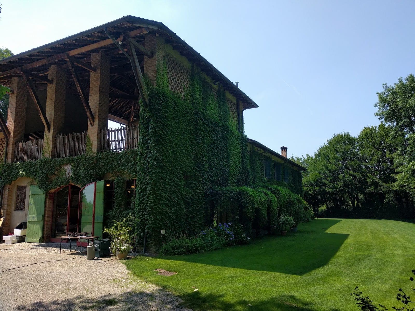 Exterior of a building covered in ivy with a large green lawn.