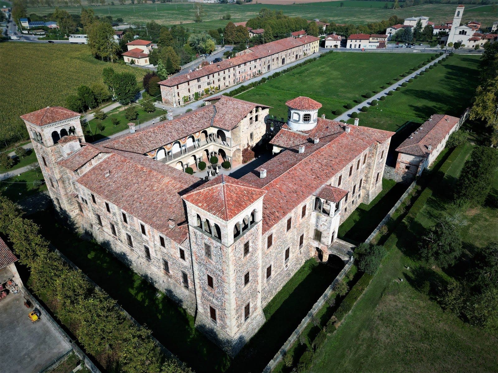 Aerial view of Cavernago Castle and its surrounding green fields.