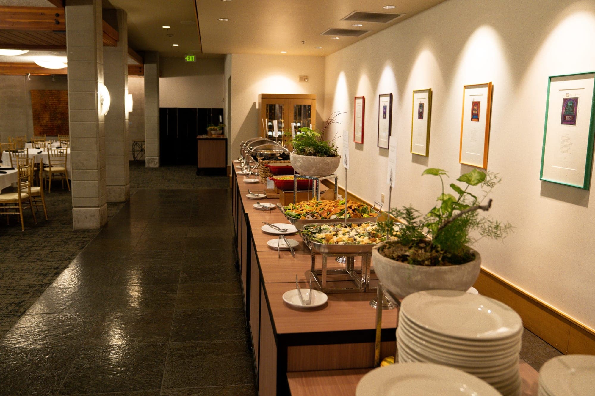 Buffet table with food and plates in a wedding venue.