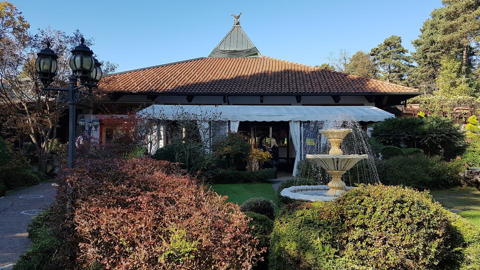 Exterior of a wedding venue with a fountain and garden.
