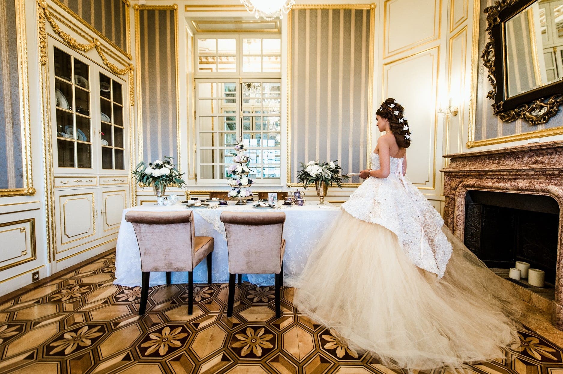 Bride in a formal dining room with a table set for a wedding reception.