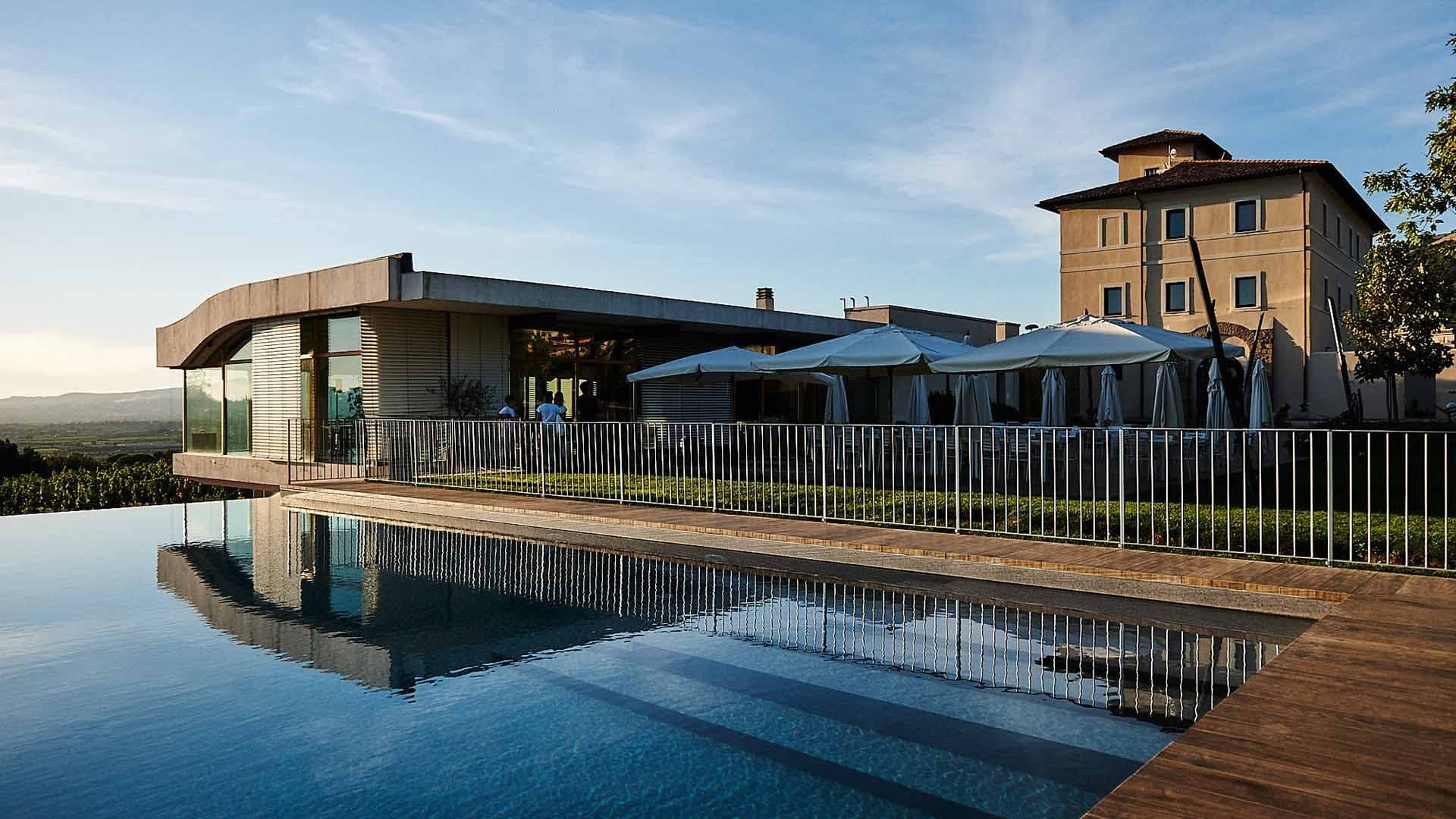 Exterior of a wedding venue with a pool and outdoor dining area.
