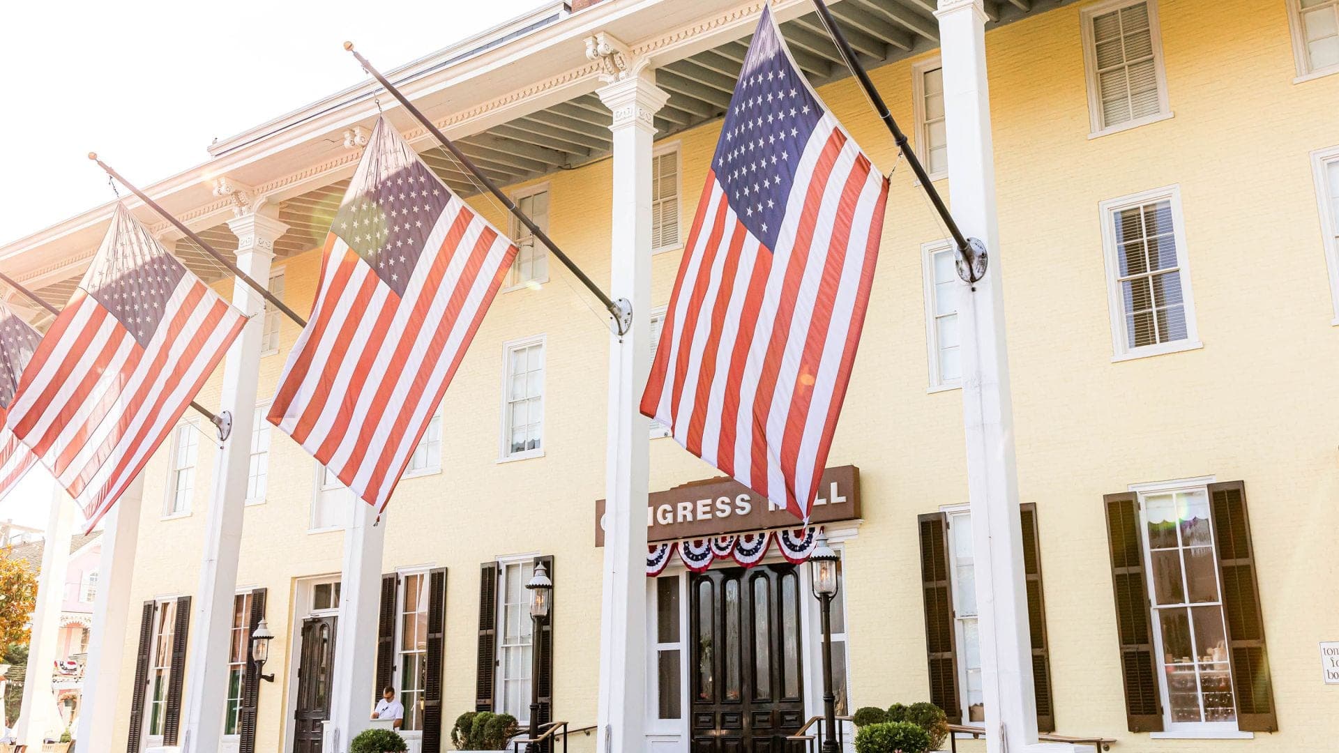 Exterior of Congress Hall with American flags and columns.