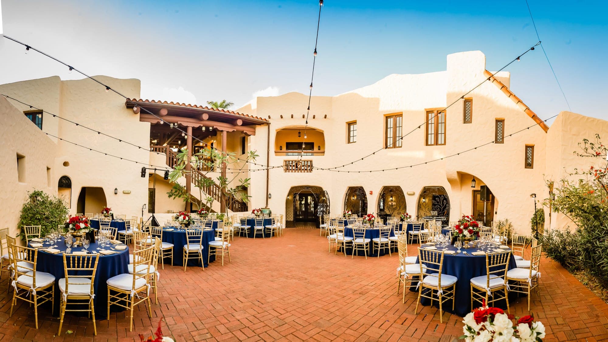Courtyard reception setup with round tables and chairs