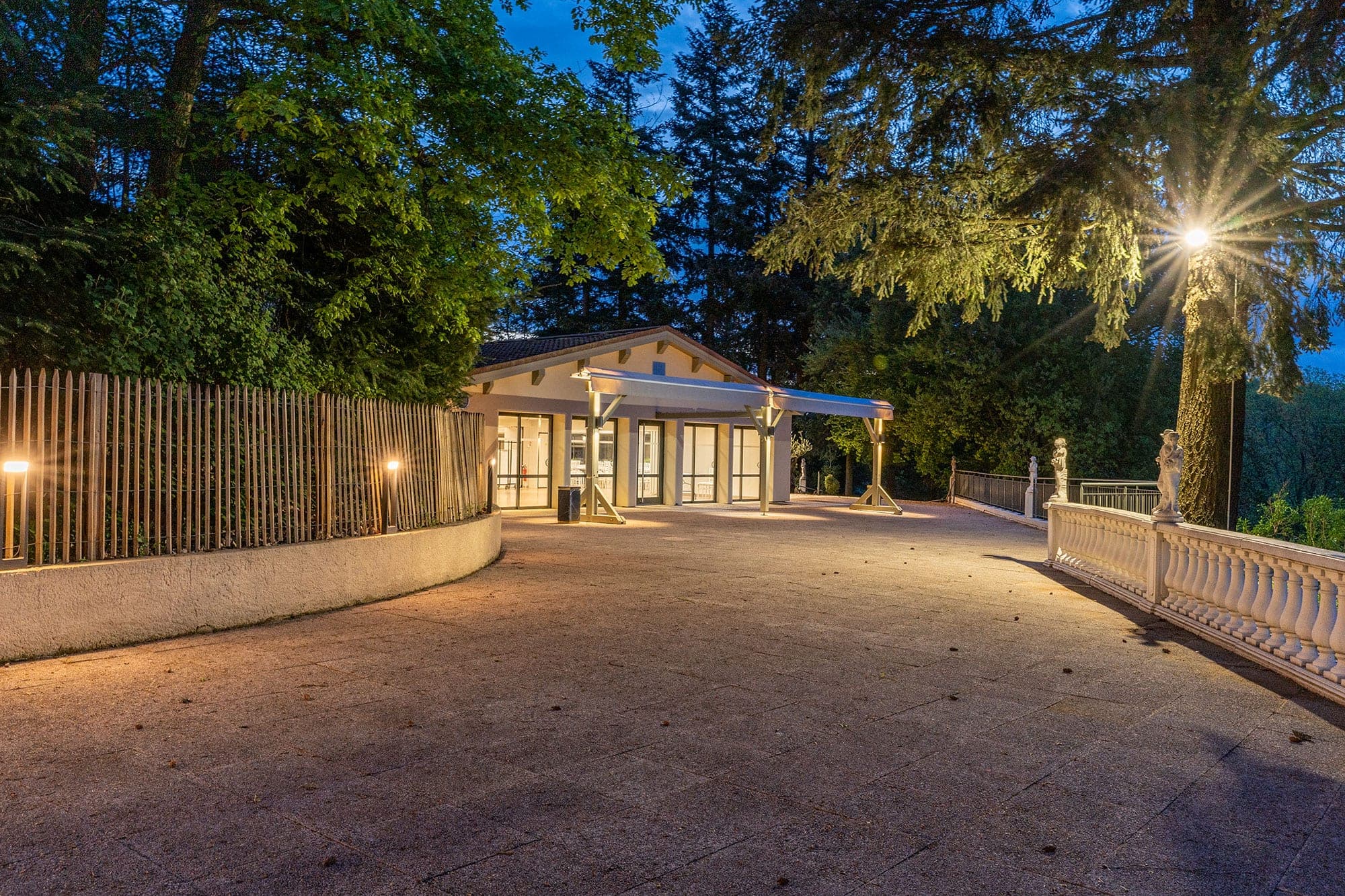 Entrance to a building at dusk with outdoor lighting.