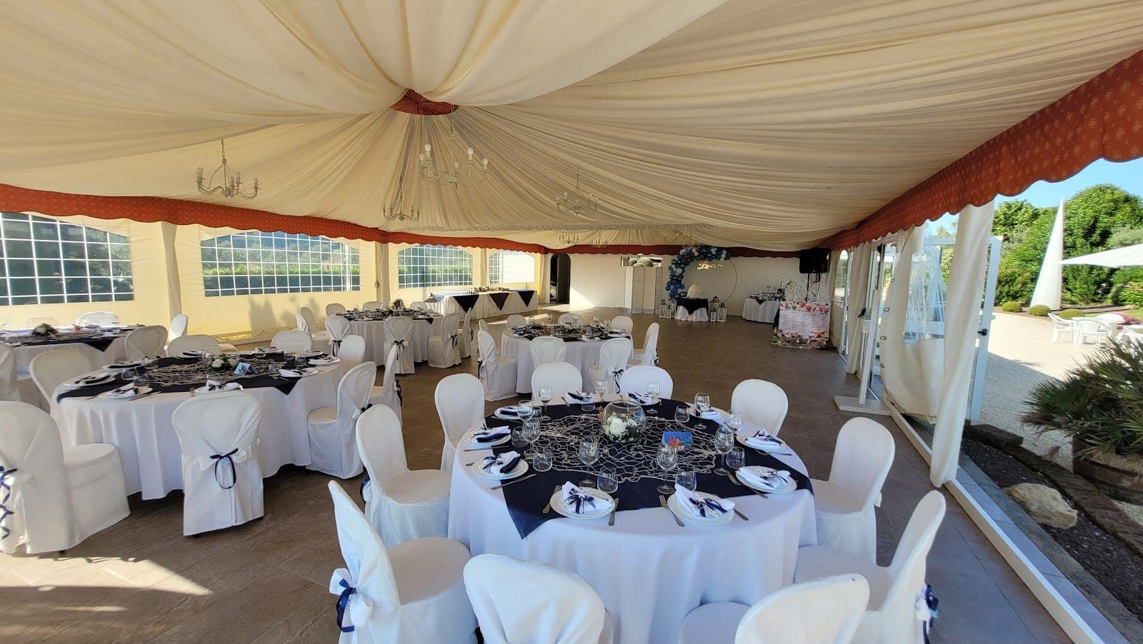 Wedding reception tent with round tables set for guests.