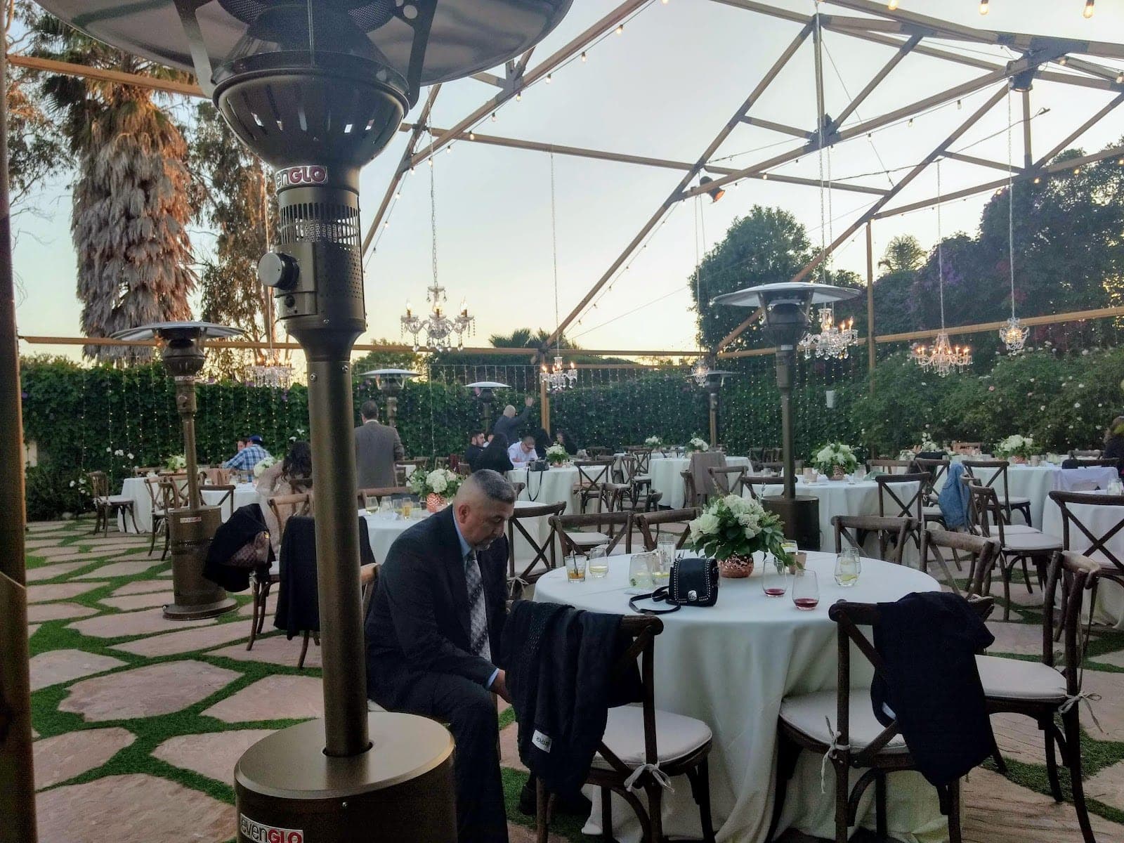 Outdoor reception area with tables set for a wedding.