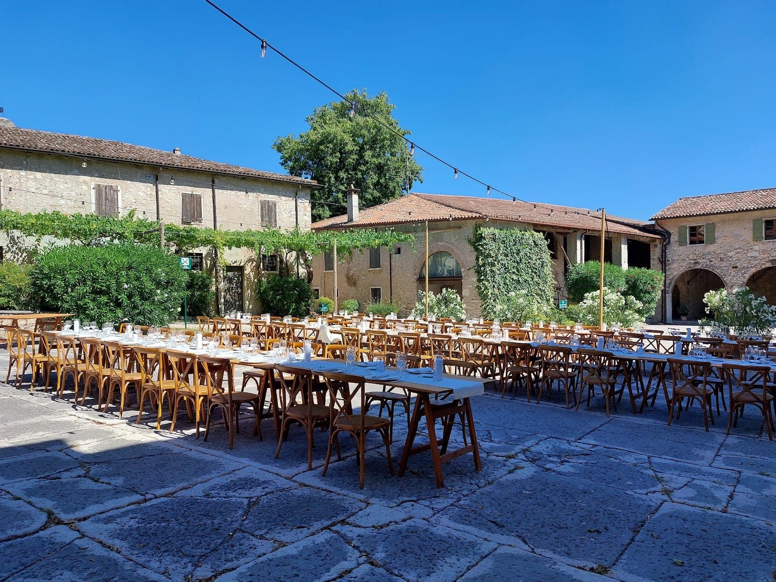 Courtyard with long tables and chairs set for a wedding reception.