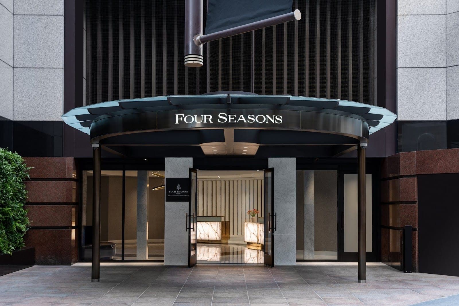 The entrance to the Four Seasons hotel with the name displayed above the doors.