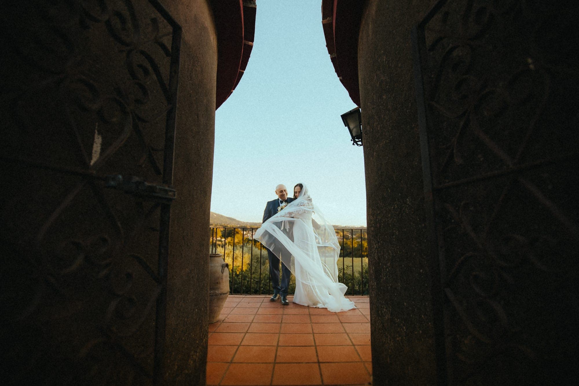 Bride and groom on a terrace with a view.