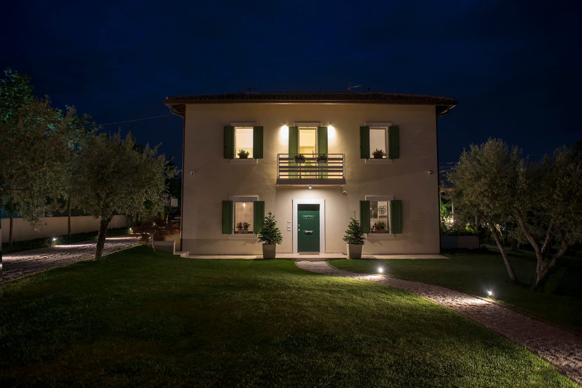 Exterior of a building at night with illuminated windows and pathways.