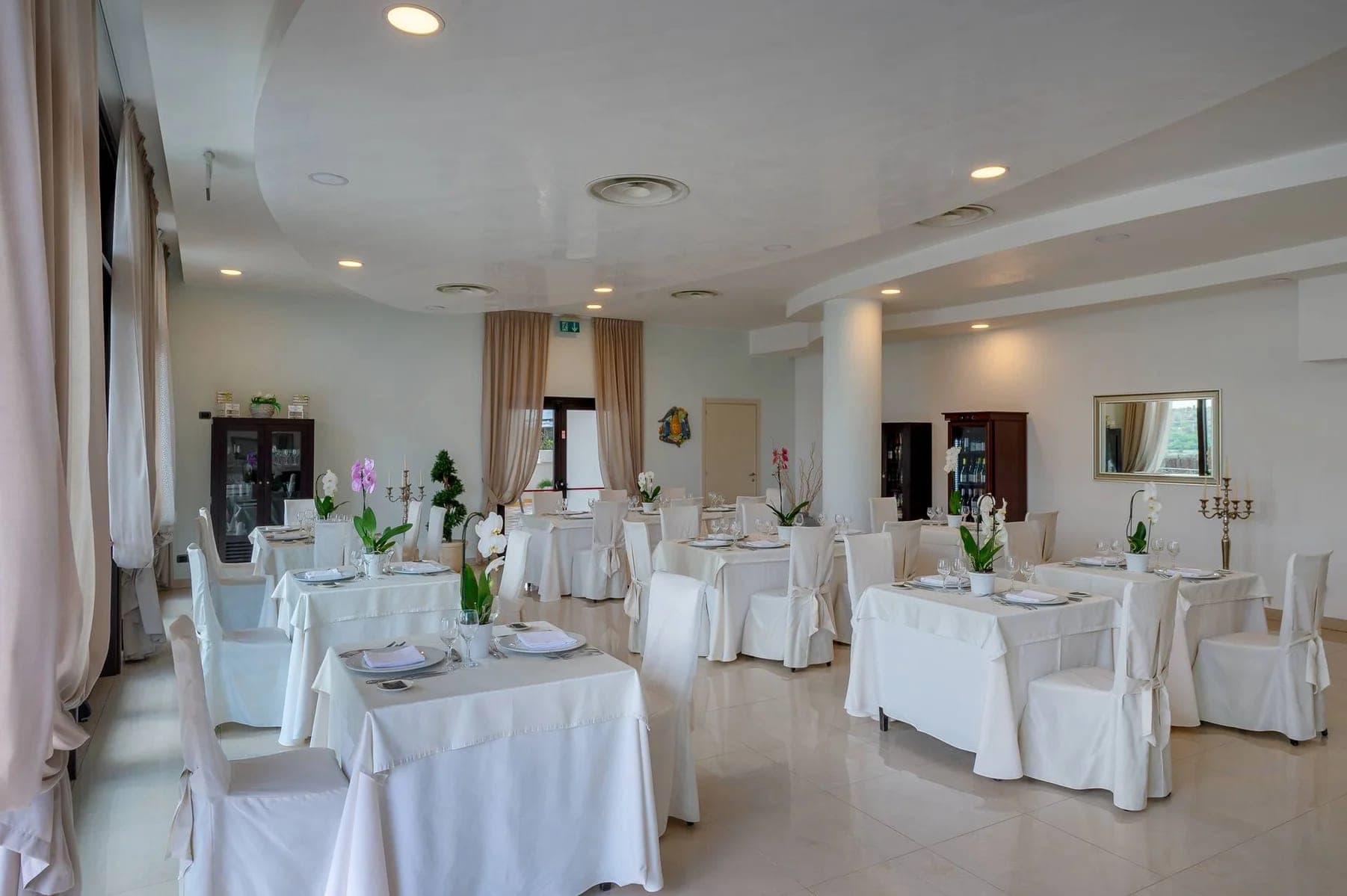 A dining room with tables set for a wedding reception.