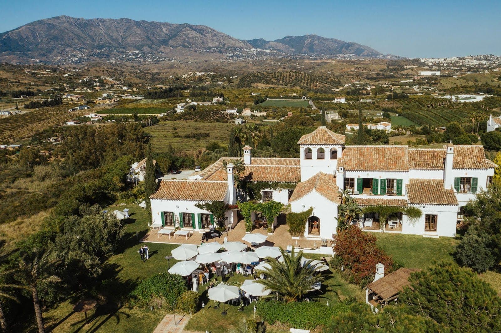 Aerial view of Hacienda San Jose with a wedding ceremony in progress on the lawn.