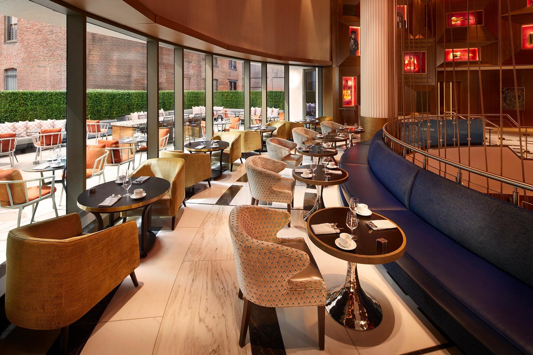 Interior dining area with tables and chairs, and outdoor seating visible through windows.