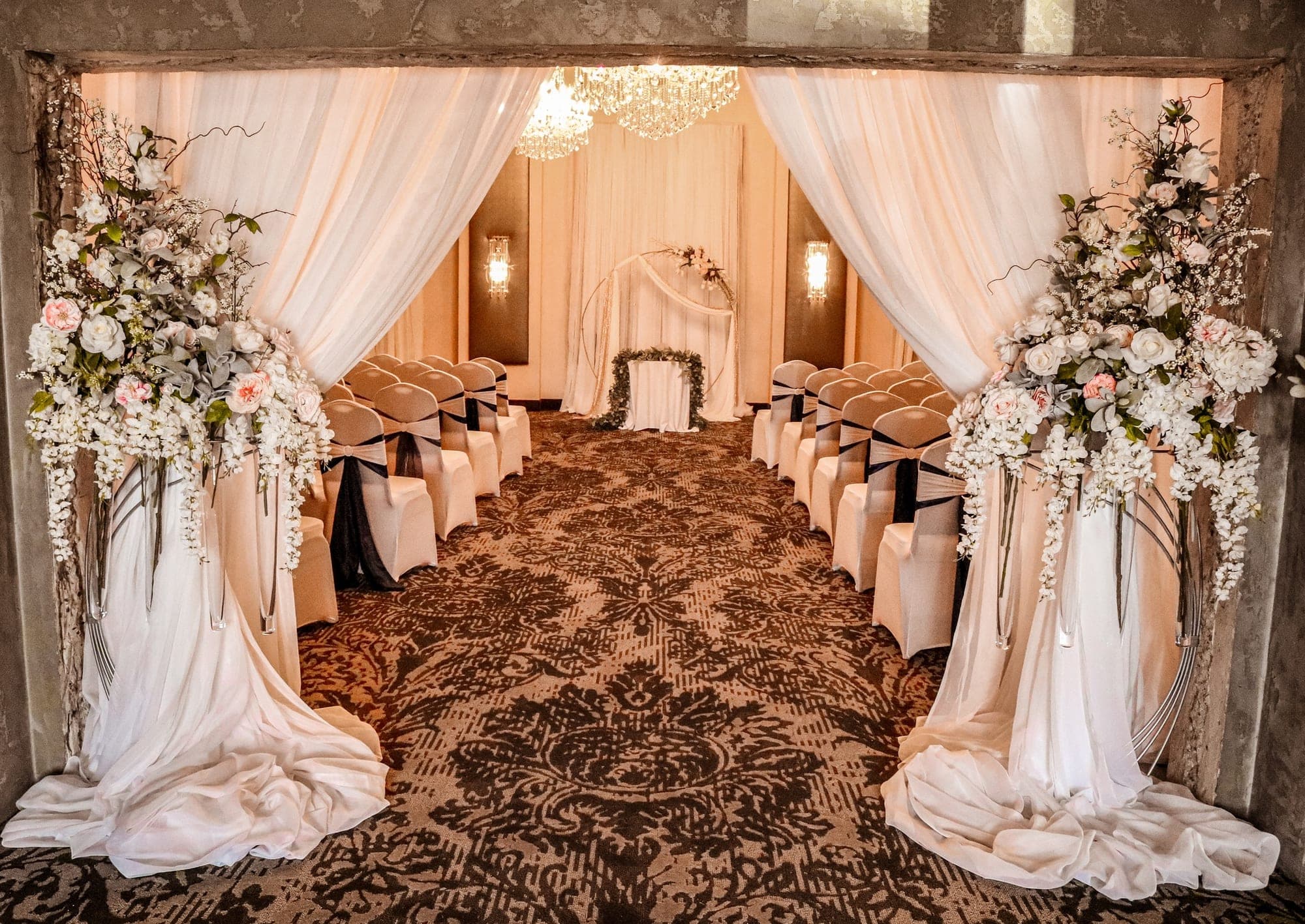 Wedding ceremony setup with rows of chairs and floral arrangements.