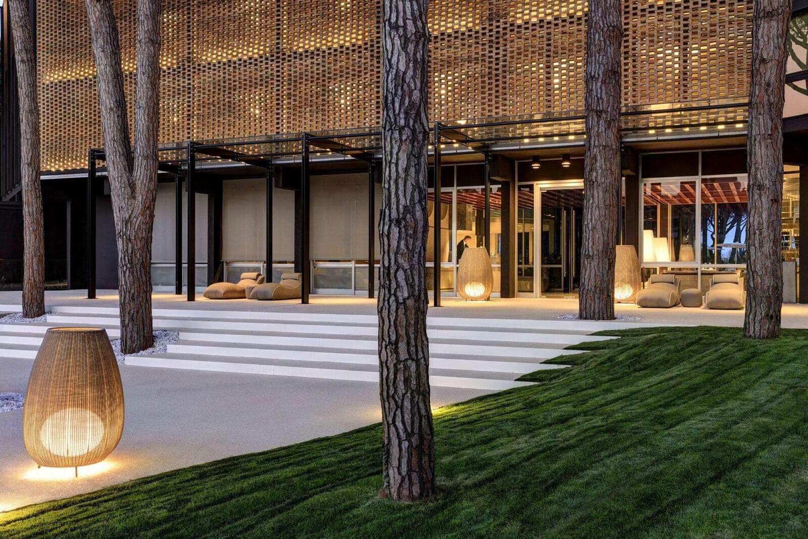 Modern building exterior with trees and outdoor lighting.