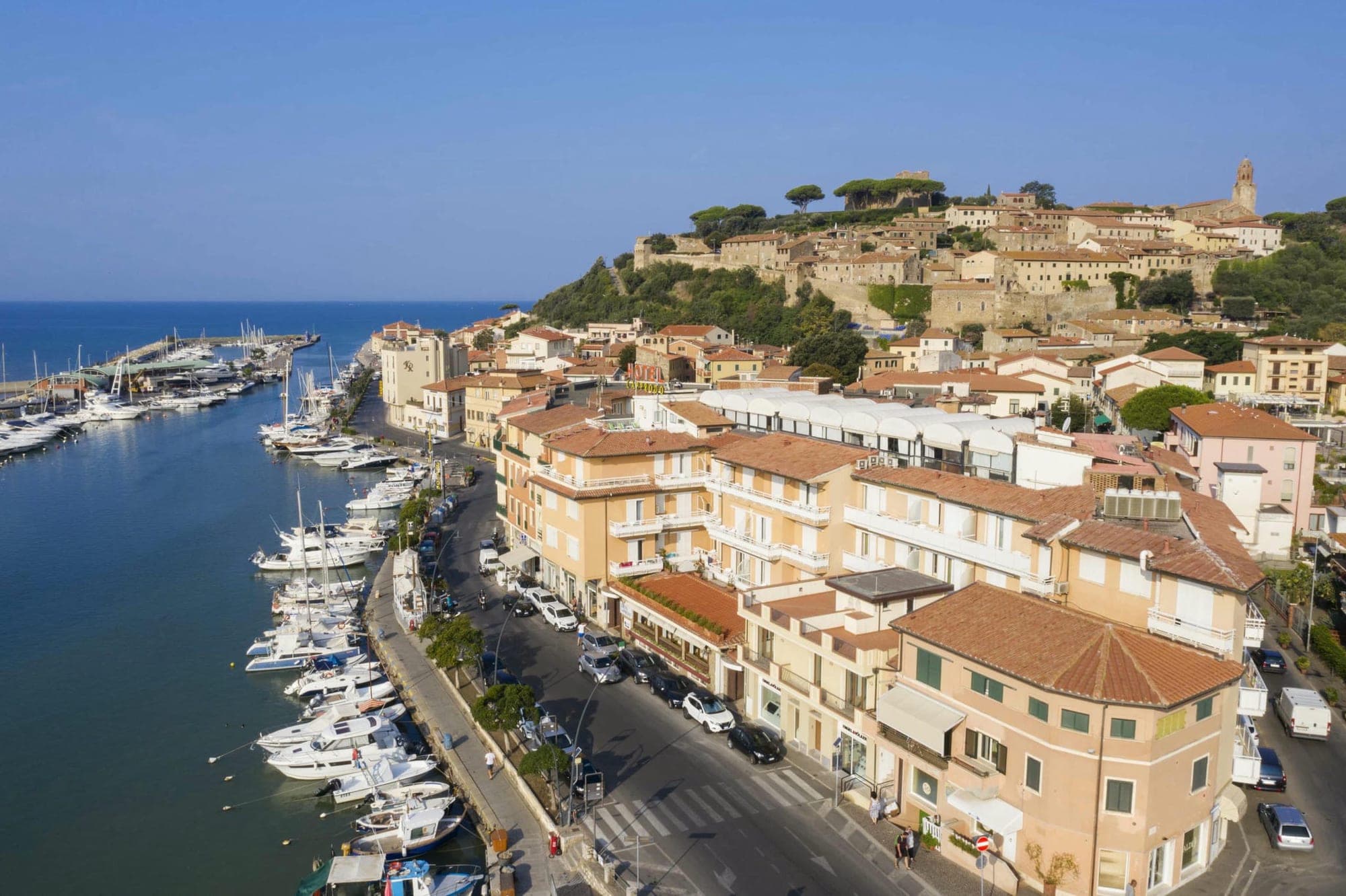 Aerial view of a coastal town with a marina and buildings.