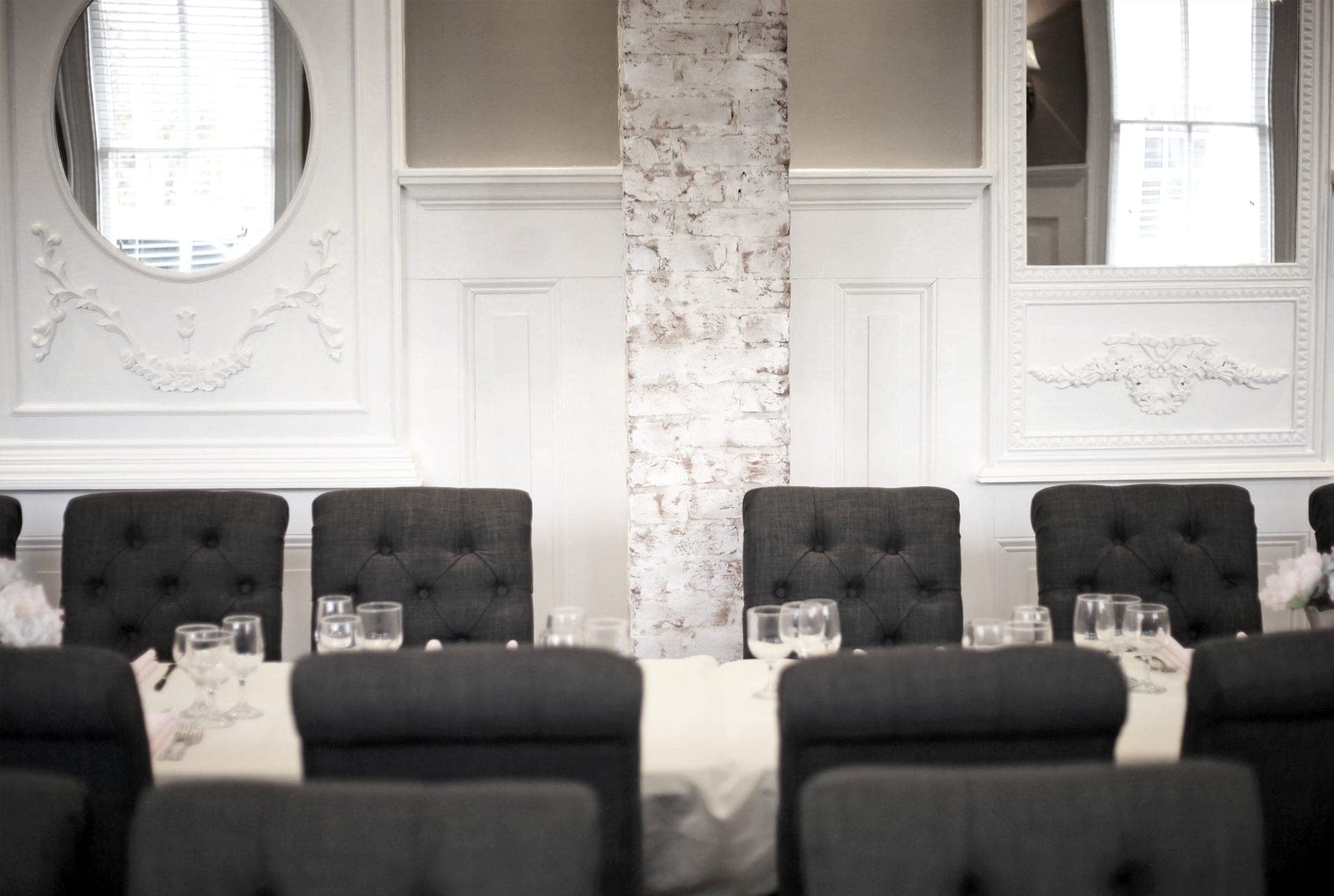 A dining table with dark chairs and place settings.
