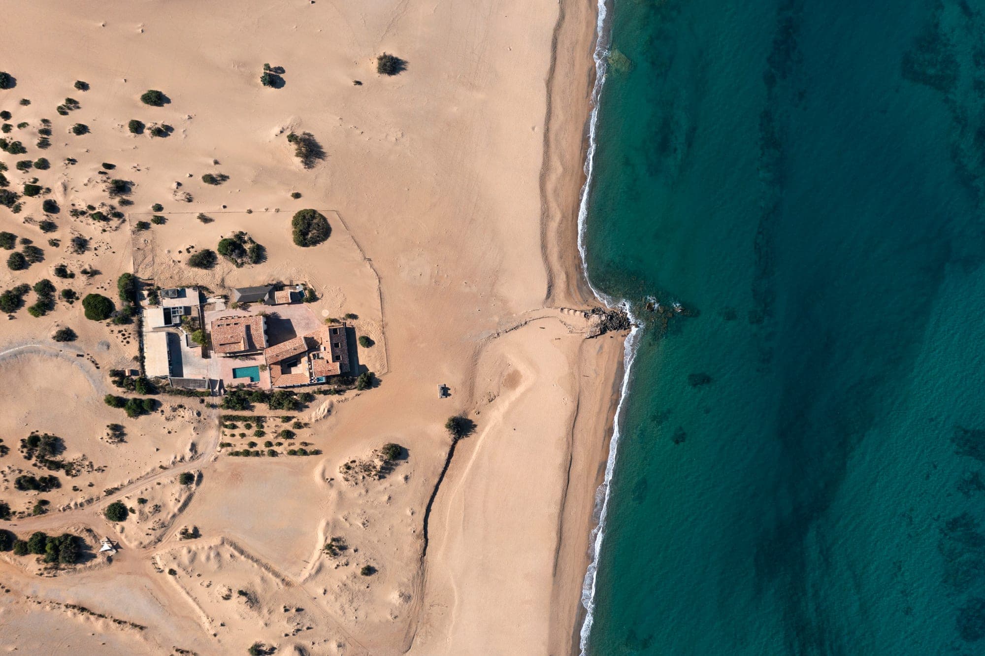 Aerial view of Hotel Le Dune Piscinas and the coastline.